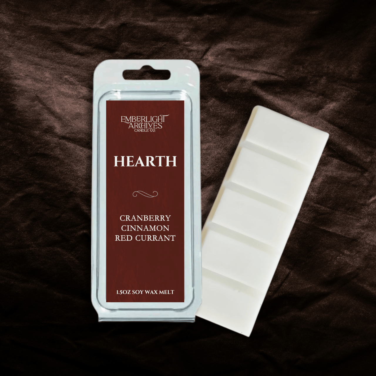 Emberlight Archives 'Hearth' cranberry cinnamon red currant soy wax melt packaging on a dark fabric background